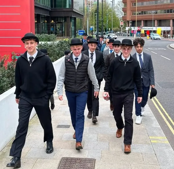 Young supporters in bowlers walking through the city on Gentry Day.